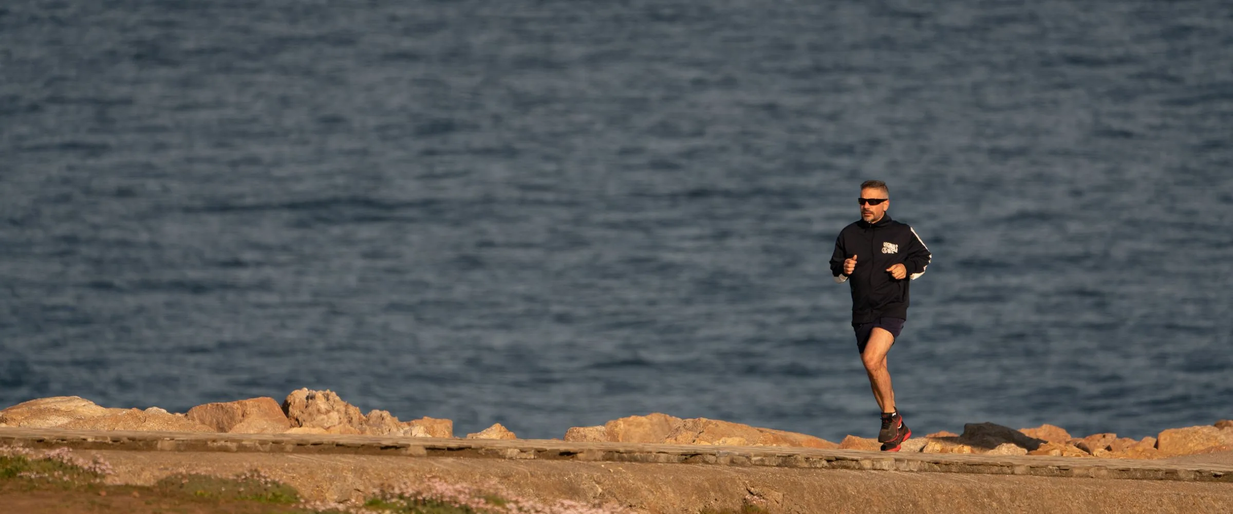 Coureurs sur un sentier de falaise au-dessus de la mer