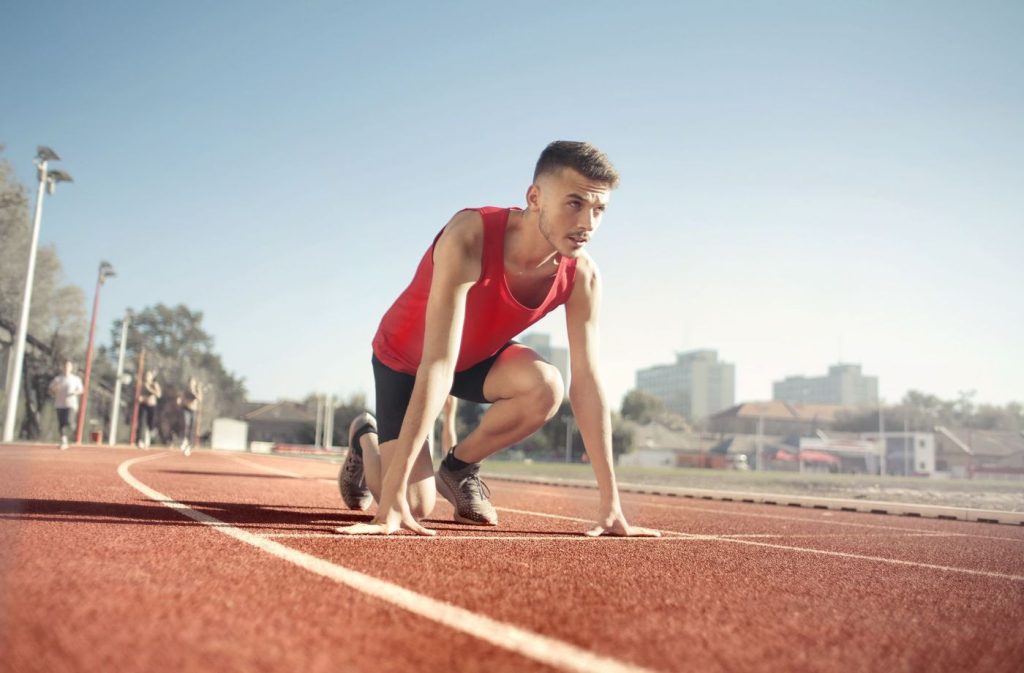Coureur en position de départ sur une piste d’athlétisme