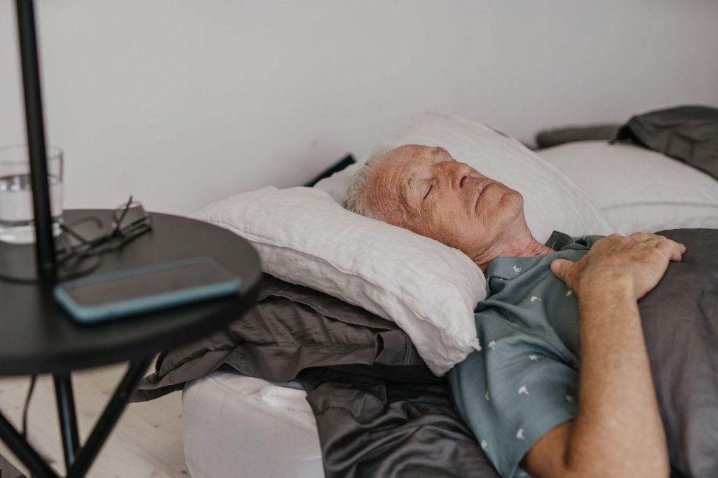 Homme âgé endormi sur son lit