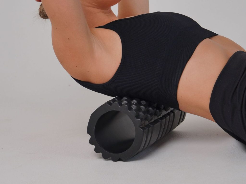 Femme allongée sur un rouleau de massage en mousse