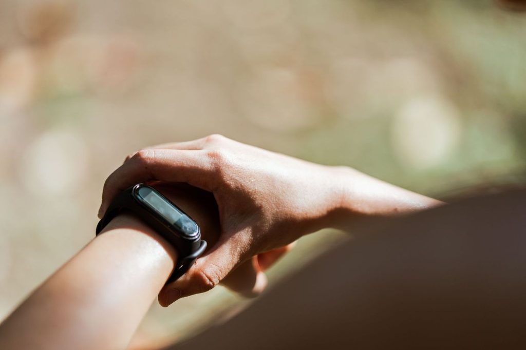 Poignet portant une montre de sport simple au soleil
