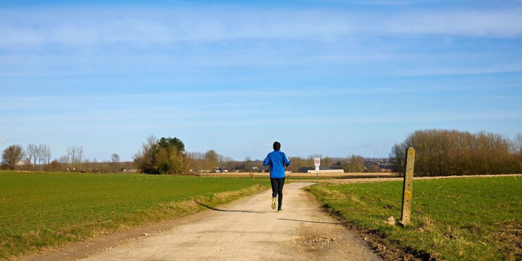 Coureur seul sur un chemin de campagne en terre