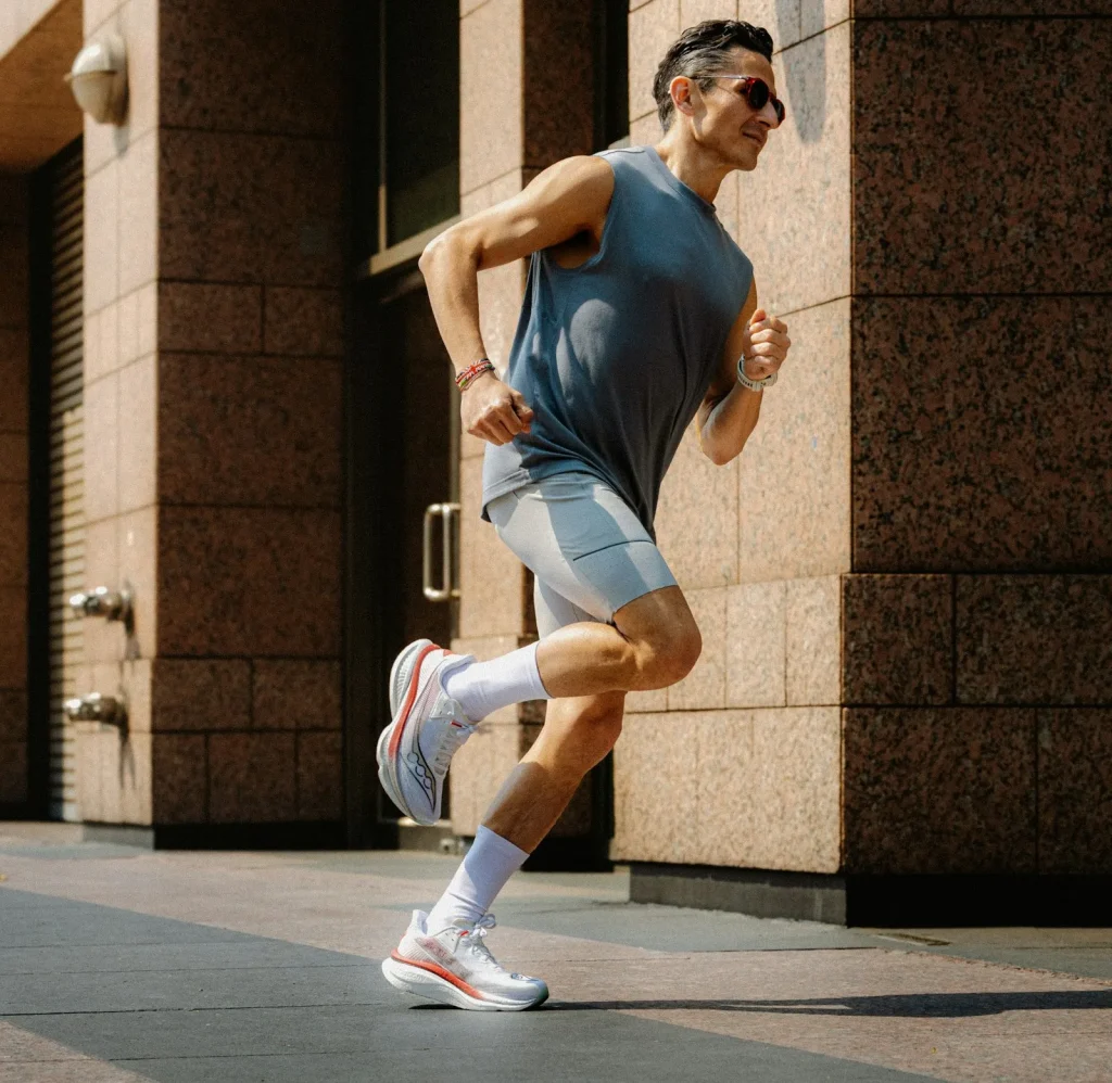 Coureur en chaussures Saucony de course sur un trottoir